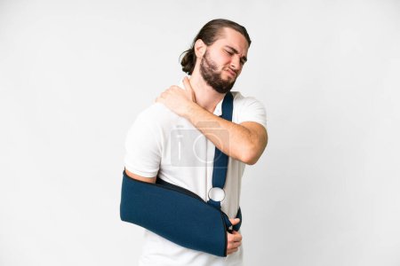 Téléchargez les photos : Young handsome man with broken arm and wearing a sling over isolated white background suffering from pain in shoulder for having made an effort - en image libre de droit