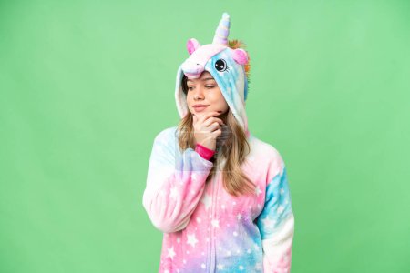 Foto de Chica joven con pijama de unicornio sobre fondo de croma clave aislada mirando a un lado - Imagen libre de derechos