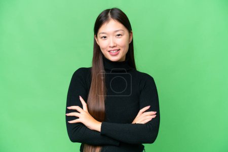 Young Asian woman over isolated chroma key background keeping the arms crossed in frontal position