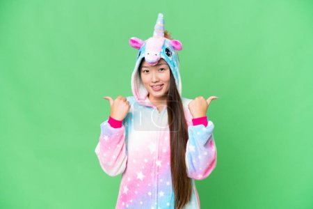 Téléchargez les photos : Young Asian woman with unicorn pajamas over isolated chroma key background with thumbs up gesture and smiling - en image libre de droit