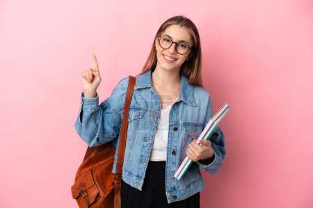 Junge kaukasische Studentin isoliert auf rosa Hintergrund zeigt und hebt einen Finger im Zeichen der besten