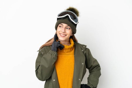 Photo for Skier caucasian woman with snowboarding glasses isolated on white background thinking an idea while looking up - Royalty Free Image