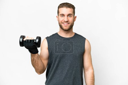 Téléchargez les photos : Jeune homme sportif faisant haltérophilie sur fond blanc isolé souriant beaucoup - en image libre de droit