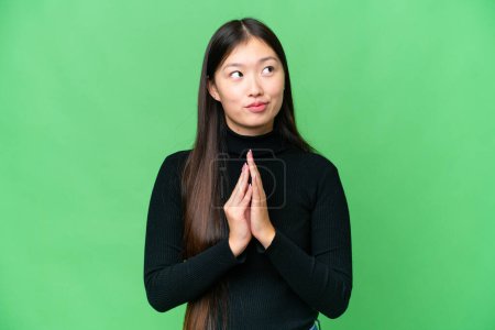 Téléchargez les photos : Young Asian woman over isolated chroma key background scheming something - en image libre de droit