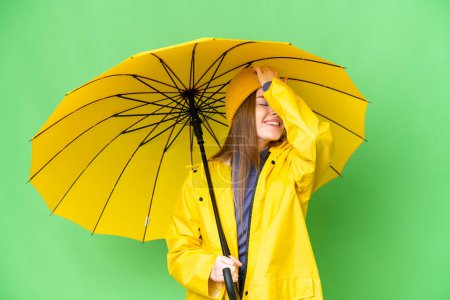 Téléchargez les photos : Young pretty woman with rainproof coat and umbrella over isolated chroma key background has realized something and intending the solution - en image libre de droit