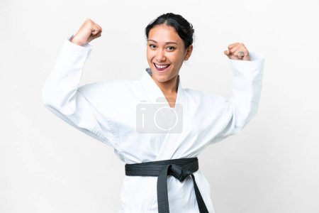 Young Uruguayan woman over isolated white background doing karate and making strong gesture