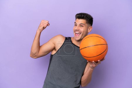 Photo for Young caucasian woman  basketball player man isolated on purple background celebrating a victory - Royalty Free Image