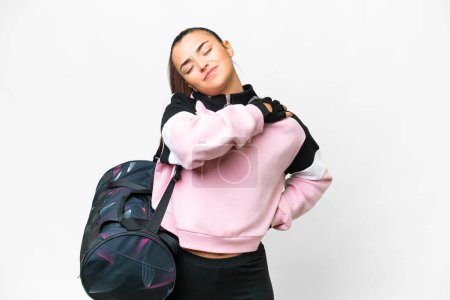 Foto de Young sport woman with sport bag over isolated white background suffering from pain in shoulder for having made an effort - Imagen libre de derechos