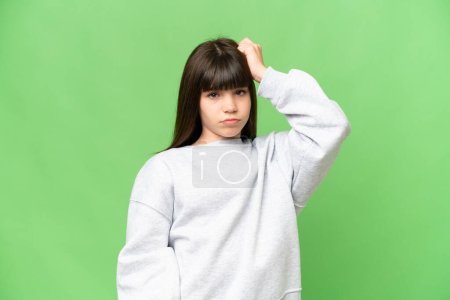 Téléchargez les photos : Petite fille sur fond de chroma vert isolé avec une expression de frustration et de ne pas comprendre - en image libre de droit