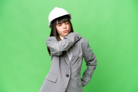 Photo for Little girl playing as a architect with helmet and holding blueprints over isolated background suffering from pain in shoulder for having made an effort - Royalty Free Image