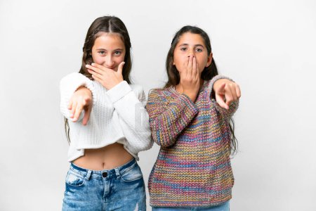 Friends girls over isolated white background pointing with finger at someone and laughing