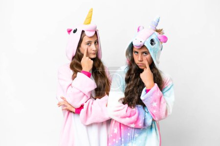 Foto de Amigos chicas con pijamas de unicornio sobre fondo blanco aislado mirando hacia el frente - Imagen libre de derechos
