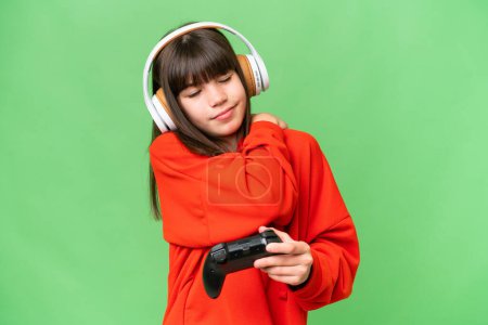 Photo for Little caucasian girl playing with a video game controller over isolated background suffering from pain in shoulder for having made an effort - Royalty Free Image
