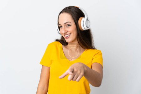 Young hispanic woman over isolated white background listening music