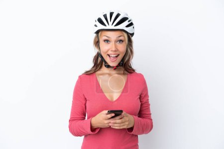 Photo for Young Russian woman wearing a bike helmet isolated on white background surprised and sending a message - Royalty Free Image