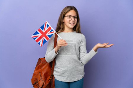 Child holding an United Kingdom flag over isolated background extending hands to the side for inviting to come