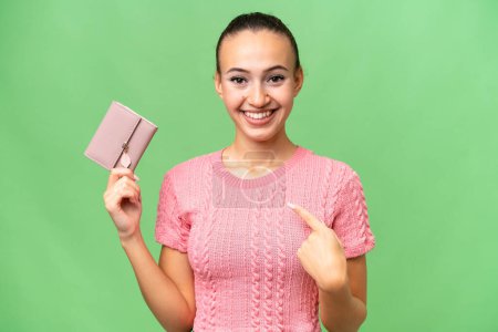 Photo for Young Arab woman holding a wallet over isolated background with surprise facial expression - Royalty Free Image