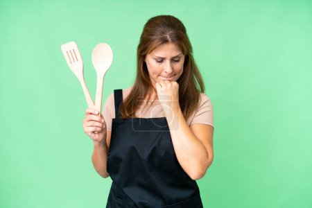 Photo for Middle age caucasian woman holding a rolling pin over isolated background having doubts - Royalty Free Image