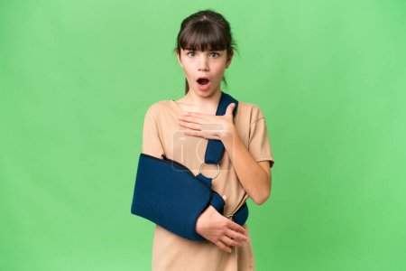 Photo for Little caucasian girl with broken arm and wearing a sling over isolated background surprised and shocked while looking right - Royalty Free Image