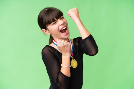 Photo for Little caucasian girl with medals over isolated background celebrating a victory - Royalty Free Image