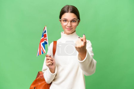 Téléchargez les photos : Adolescente étudiante caucasienne tenant un drapeau du Royaume-Uni sur fond isolé faisant geste à venir - en image libre de droit