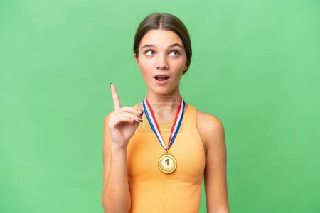 Photo for Teenager caucasian girl with medals over isolated background thinking an idea pointing the finger up - Royalty Free Image