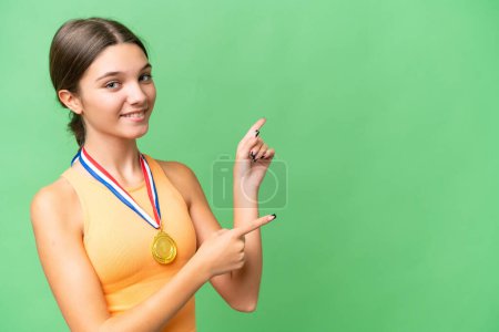 Photo for Teenager caucasian girl with medals over isolated background pointing finger to the side and presenting a product - Royalty Free Image