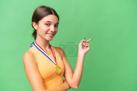 Photo for Teenager caucasian girl with medals over isolated background pointing finger to the side - Royalty Free Image