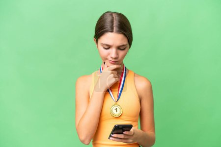 Photo for Teenager caucasian girl with medals over isolated background thinking and sending a message - Royalty Free Image