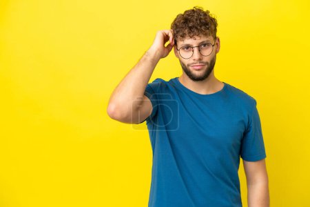 Téléchargez les photos : Jeune homme caucasien beau isolé sur fond jaune avec une expression de frustration et de ne pas comprendre - en image libre de droit
