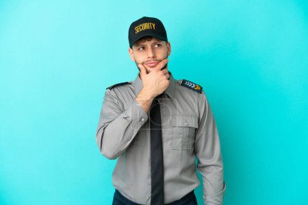 Photo for Young security man isolated on blue background having doubts and with confuse face expression - Royalty Free Image