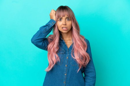 Téléchargez les photos : Jeune femme métisse aux cheveux roses isolé sur fond bleu avec une expression de frustration et de ne pas comprendre - en image libre de droit