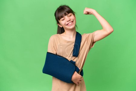 Photo for Little caucasian girl with broken arm and wearing a sling over isolated background doing strong gesture - Royalty Free Image
