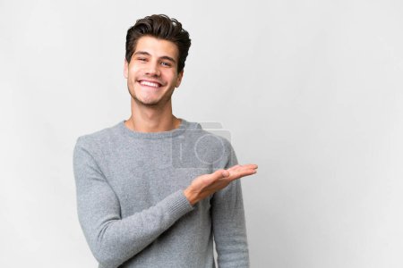 Photo for Young handsome caucasian man over isolated white background presenting an idea while looking smiling towards - Royalty Free Image