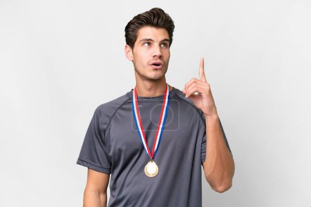 Photo for Young caucasian man with medals over isolated white background thinking an idea pointing the finger up - Royalty Free Image