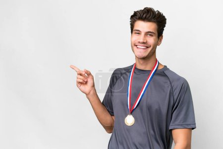 Photo for Young caucasian man with medals over isolated white background pointing finger to the side - Royalty Free Image