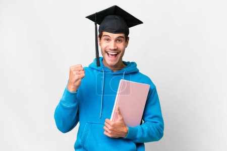 Téléchargez les photos : Jeune diplômé universitaire sur fond blanc isolé célébrant une victoire en position de vainqueur - en image libre de droit