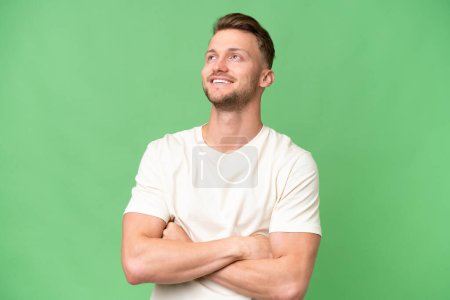 Photo for Young blonde caucasian man over isolated background looking up while smiling - Royalty Free Image
