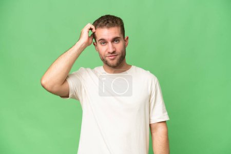 Foto de Joven hombre caucásico guapo aislado en fondo de croma verde con una expresión de frustración y falta de comprensión - Imagen libre de derechos