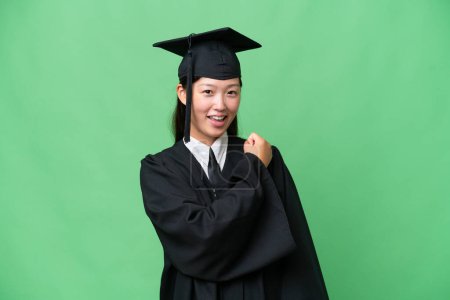 Téléchargez les photos : Jeune diplômée universitaire asiatique sur fond isolé célébrant une victoire - en image libre de droit