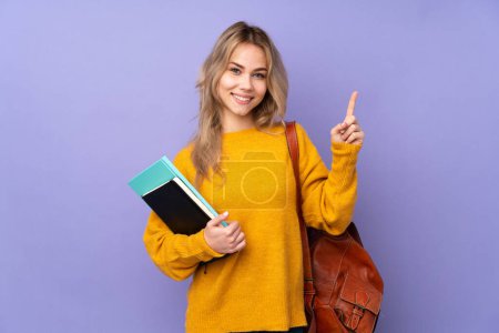 Adolescente estudiante rusa chica aislado en púrpura fondo mostrando y levantando un dedo en señal de la mejor