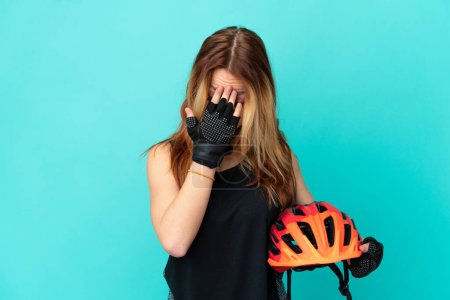 Téléchargez les photos : Jeune fille cycliste sur fond bleu isolé avec expression fatiguée et malade - en image libre de droit