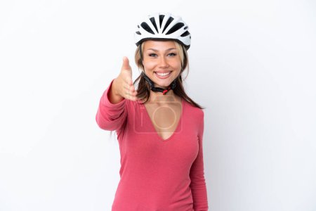 Téléchargez les photos : Jeune femme russe portant un casque de vélo isolé sur fond blanc serrant la main pour conclure une bonne affaire - en image libre de droit