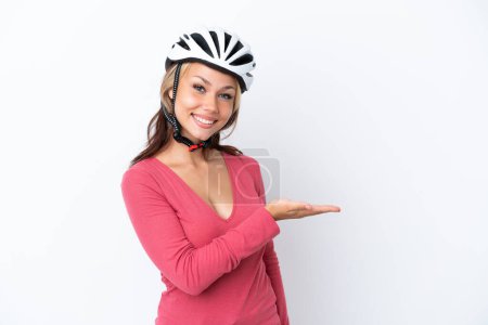 Photo for Young Russian woman wearing a bike helmet isolated on white background presenting an idea while looking smiling towards - Royalty Free Image