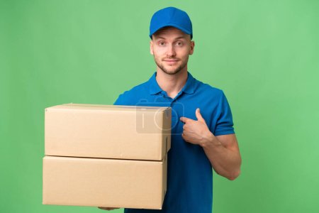 Delivery caucasian man over isolated background with surprise facial expression