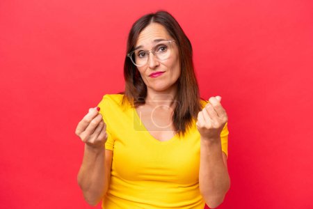 Photo for Middle-aged caucasian woman isolated on red background making money gesture but is ruined - Royalty Free Image