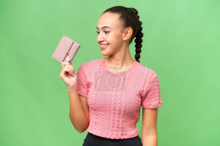 Photo for Young Arab woman holding a wallet over isolated background with happy expression - Royalty Free Image