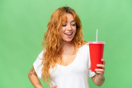 Foto de Joven mujer caucásica sosteniendo soda aislada en pantalla verde croma clave fondo - Imagen libre de derechos