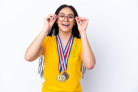 Photo for Teenager girl with braids and medals over isolated pink background with glasses and surprised - Royalty Free Image