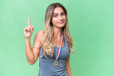 Photo for Young pretty sport Uruguayan woman with medals over isolated background pointing with the index finger a great idea - Royalty Free Image